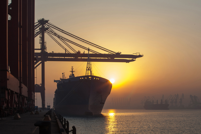 Container ship and cranes at sunset